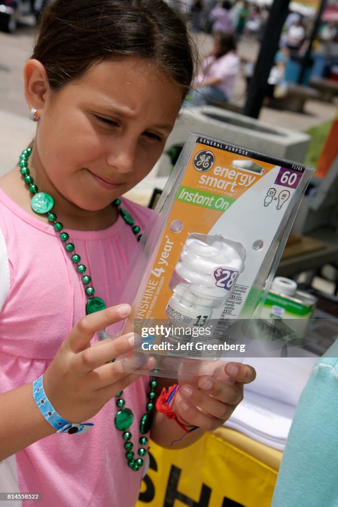 A girl looking at an energy smart light bulb at the Miami Goin' Green event