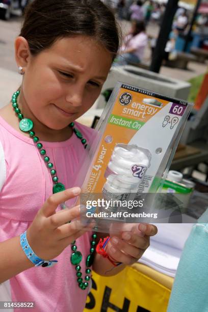 Girl looking at an energy smart light bulb at the Miami Goin' Green event.