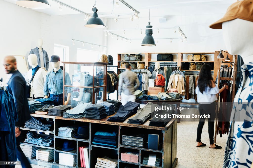 Shoppers looking at items in mens clothing boutique