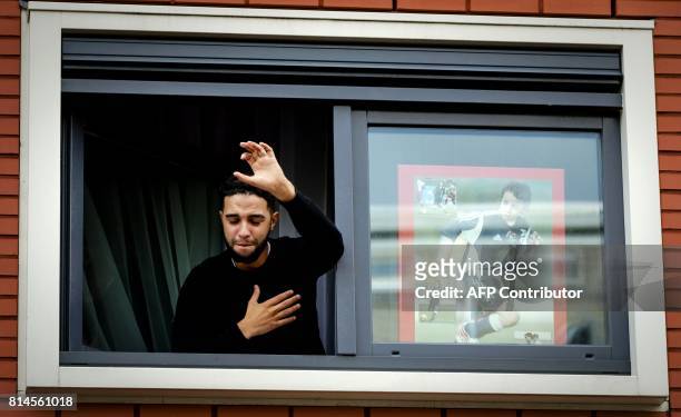 Brother of Dutch midfielder Abdelhak Nouri, Mohammed, thanks fans out of the window of the house of Abdelhak Nouri on July 14, 2017 in Amsterdam....