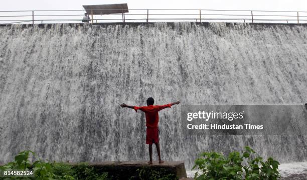 Children play in the overflowed Powai Lake water on Saturday evening. Powai lake in the city that supplies water for industrial use overflowed at...