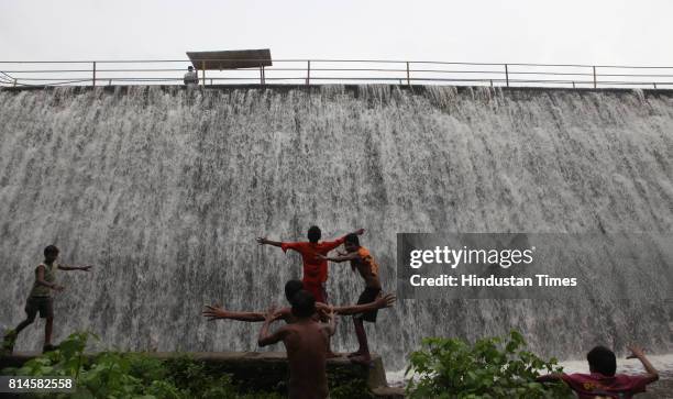 Children play in the overflowed Powai Lake water on Saturday evening. Powai lake in the city that supplies water for industrial use overflowed at...