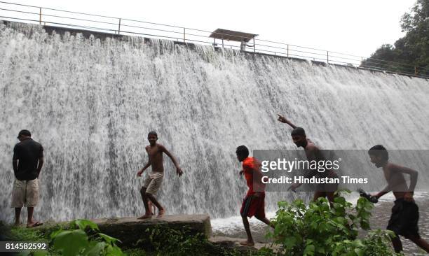 Children play in the overflowed Powai Lake water on Saturday evening. Powai lake in the city that supplies water for industrial use overflowed at...