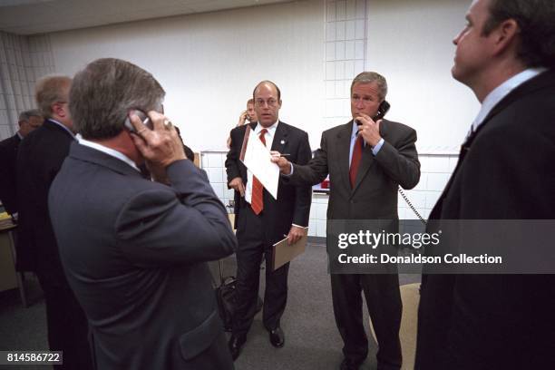 Surrounded by his staff, President George W. Bush calls New York Governor George Pataki, FBI Director Robert Mueller and Vice President Dick Cheney...