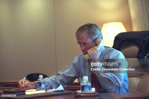 President George W. Bush confers with staff via telephone Tuesday, Sept. 11 from his office aboard Air Force One during the flight from Sarasota to...