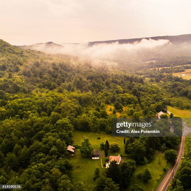 aerial drone view to the blue mountains covered by low clouds, poconos, pennsylvania, at the early morning. - mount pocono pennsylvania stock pictures, royalty-free photos & images