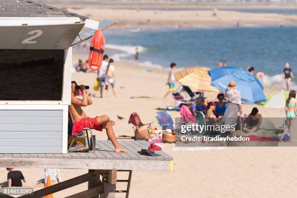 lifeguard watches from tower in seal beach, ca - beach lifeguard stock pictures, royalty-free photos & images