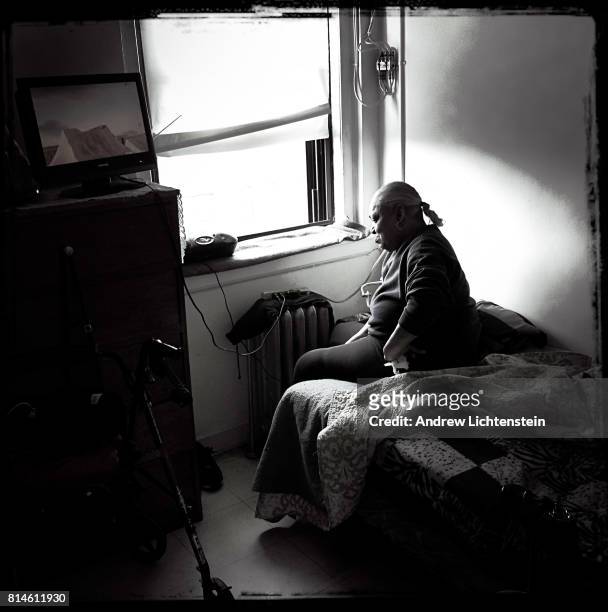 Woman sits on her bed in her single room occupancy home in the YWA on May 31, 2017 in downtown Brooklyn, New York. Located in the heart of rapidly...
