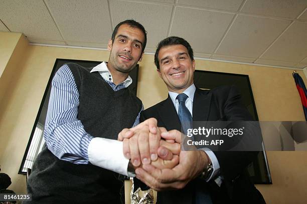 Barcelona president Joan Laporta shakes hands with his new coach and former Barcelona player Pep Guardiola after he signed a two-year contract to...