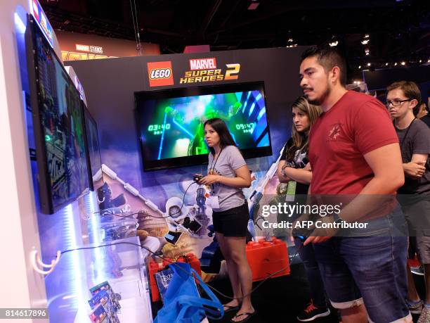 Fans try video games at the D23 expo fan convention at the convention center in Anaheim, on July 14, 2017. / AFP PHOTO / CHRIS DELMAS