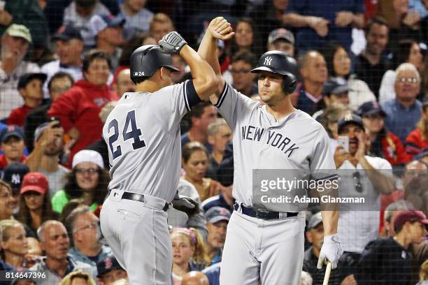Gary Sanchez high fives Matt Holiday of the New York Yankees after hitting a two-run home run in the fifth inning of a game against the Boston Red...