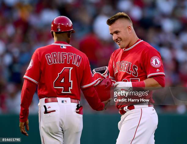 Mike Trout of the Los Angeles Angels reacts to his pop fly out with infield coach Alfredo Griffin to end the first inning against the Tampa Bay Rays...