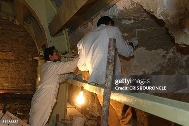 Labourers work in the underground galleries in the Saqqara Serapeum, a tunnel of underground tombs, during renovation works in Saqqara in the...