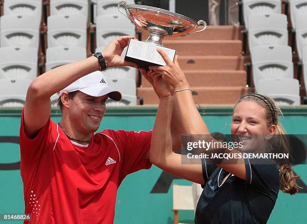 Bob Bryan and Belarus Victoria Azarenka hold up their trophy after winning against Slovak player Katarina Srebotnik and Serbian Nenad Zimonjic during...