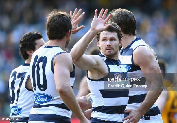 Patrick Dangerfield of the Cats is congratulated by team mates after kicking a goal during the round 17 AFL match between the Geelong Cats and the...
