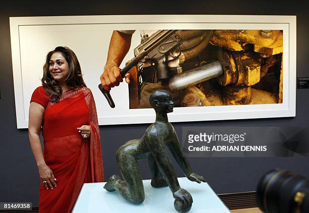 Tina Ambani, founder and patron of Harmony Art Foundation stands beside a sculpture entitled "Moving Mountains 2" by artist Dhruva Mistry and a...