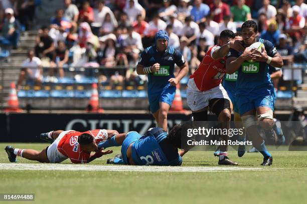 Steven Luatua of the Blues offloads the ball to Gerard Cowley-Tuioti of the Blues during the Super Rugby match between the Sunwolves and the Blues at...