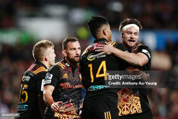 Damian McKenzie of the Chiefs celebrates with teammates Aaron Cruden and Solomon Alaimalo after scoring a try during the round 17 Super Rugby match...