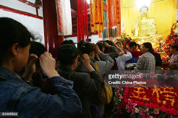 Parents of high-school graduates pray prior to their children taking the National College Entrance Examination, during a buddhist ceremony at the...