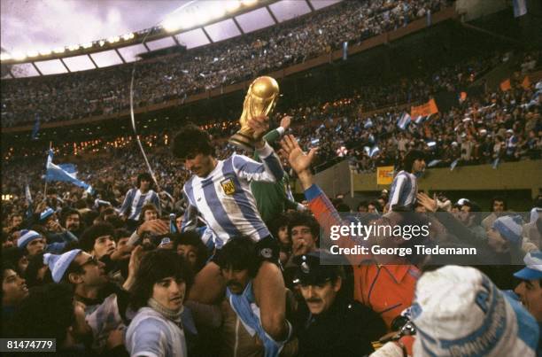 Soccer: World Cup Final, Argentina Daniel Passarella victorious with trophy, getting carried off field by teammates after winning game vs...