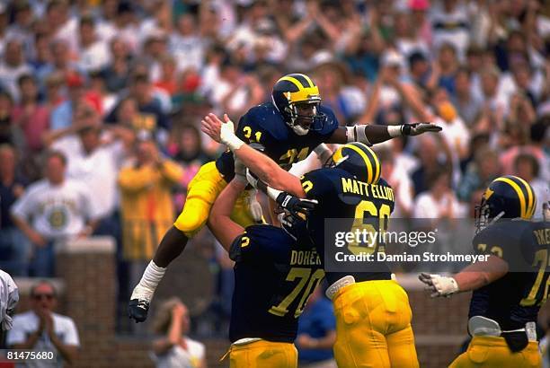 College Football: Michigan Desmond Howard victorious with teammates after scoring touchdown during 4th down play vs Notre Dame, Ann Arbor, MI...