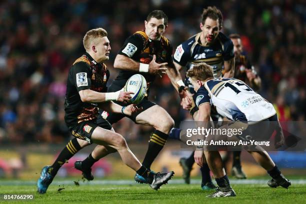 Damian McKenzie of the Chiefs looks to offload to teammate Stephen Donald during the round 17 Super Rugby match between the Chiefs and the Brumbies...