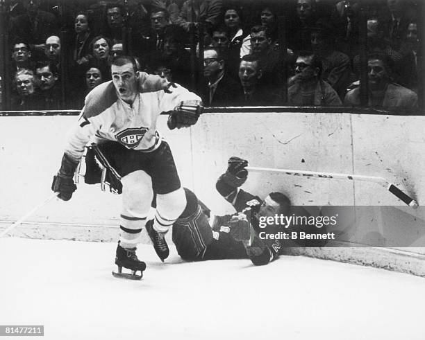 Canadian ice hockey player Jean-Guy Talbot of the Montreal Canadiens leaves Ted Hampson of the New York Rangers on his back against the boards after...