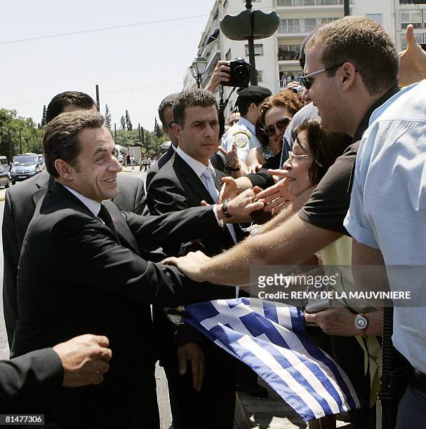 France's President Nicolas Sarkozy shakes hand with people after laying a wreath on the tomb of the unknown soldier in Athens, in Greece, on June 6,...