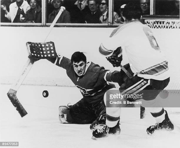 Canadian ice hockey player Rogatien Vachon , goalkeeper for the Montreal Canadiens, deflects the puck as Jim Roberts of the St. Louis Blues skates at...