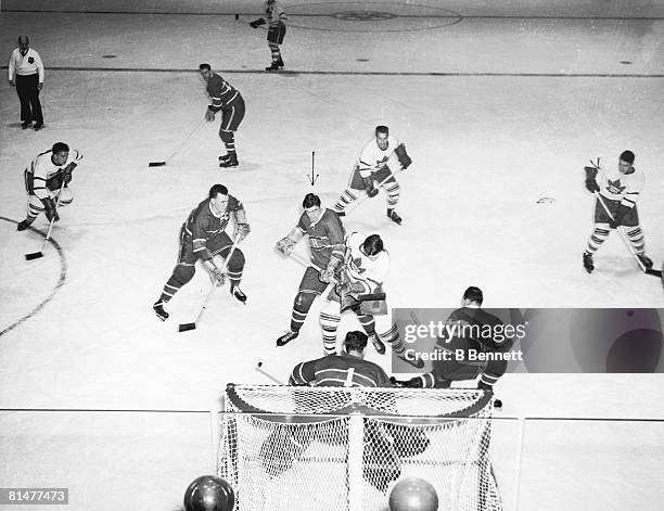 Action in front of the bet during an ice hockey game between the Montreal Canadiens and the Toronto Maple Leafs, 1940s. Among those pictured are...