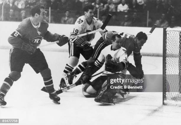 Canadian ice hockey player Glen Hall, goalkeeper for the Chicago Blackhawks glances behind him as a shot from Dick Duff of the Montreal Canadiens...