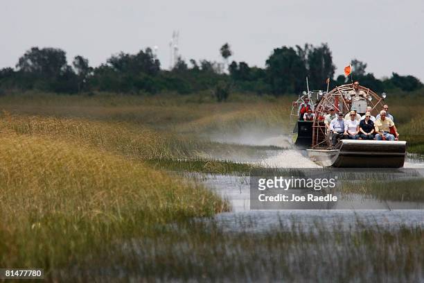 Republican presidential candidate John McCain rides on an airboat as he visits the Everglades June 6, 2008 in Miami, Florida. Seated in the front row...