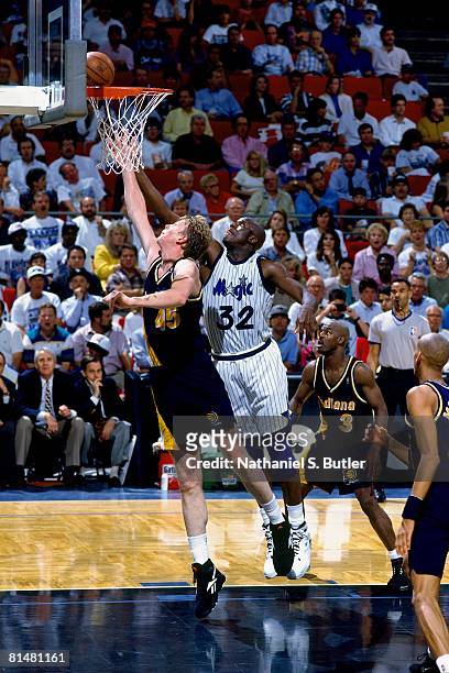 Rick Smits of the Indiana Pacers shoots a layup against Shaquille O'Neal of the Orlando Magic in Game One of the Eastern Conference Quarterfinals...