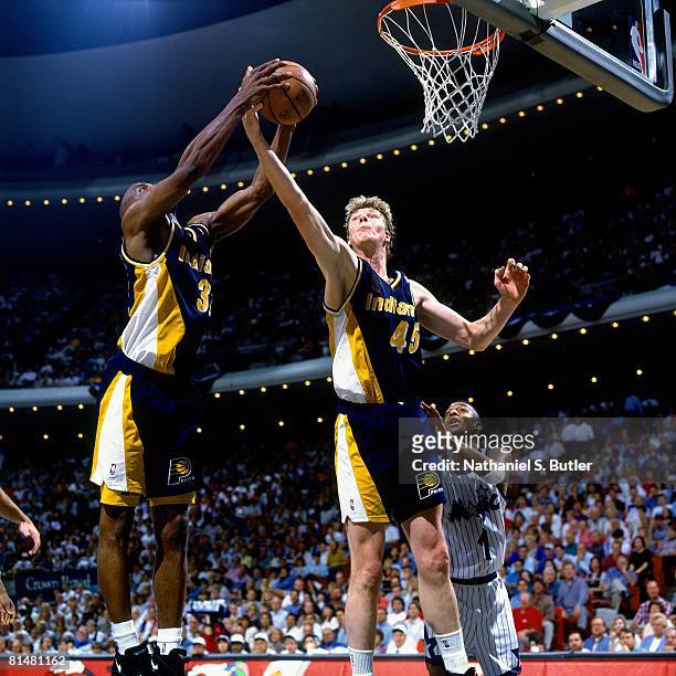 Rick Smits and Dale Davis of the Indiana Pacers team up for a rebound against the Orlando Magic in Game One of the Eastern Conference Quarterfinals...