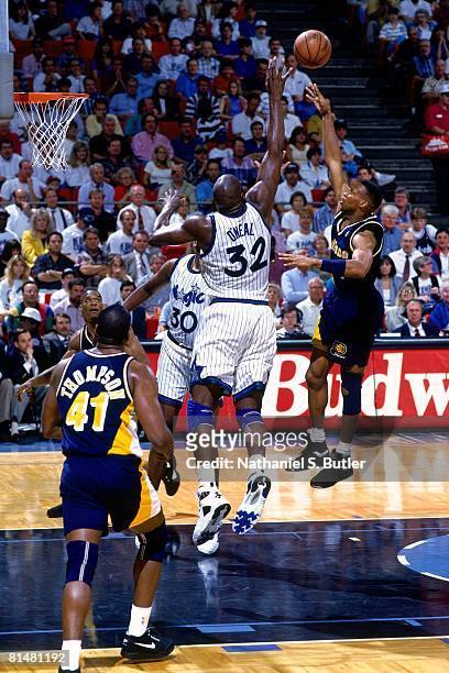 Byron Scott of the Indiana Pacers shoots over Shaquille O'Neal of the Orlando Magic in Game One of the Eastern Conference Quarterfinals during the...