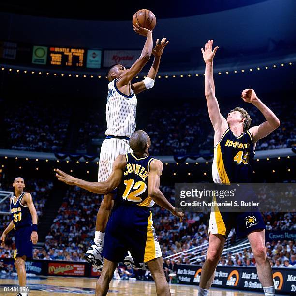 Anfernee "Penny" Hardaway of the Orlando Magic shoots over Lester Conner and Rick Smits of the Indiana Pacers in Game One of the Eastern Conference...