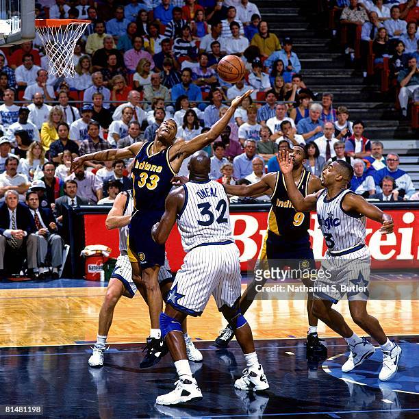 Dale Davis of the Indiana Pacers rebounds against Shaquille O'Neal of the Orlando Magic in Game One of the Eastern Conference Quarterfinals during...