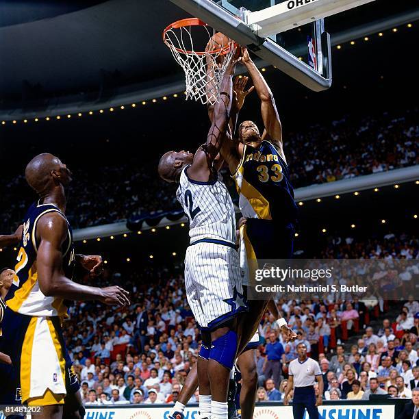 Antonio Davis of the Indiana Pacers dunks over Shaquille O'Neal of the Orlando Magic in Game One of the Eastern Conference Quarterfinals during the...