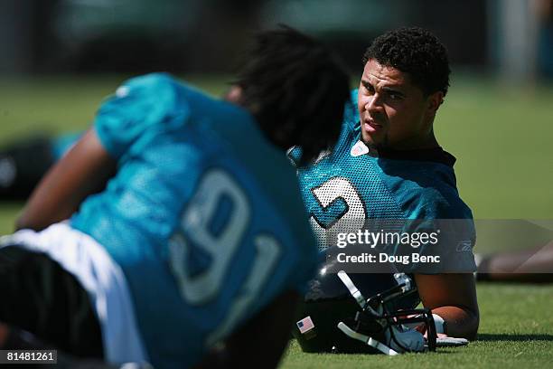 Linebacker Thomas Williams and defensive end Derrick Harvey of the Jacksonville Jaguars stretch during mini camp Jacksonville Municipal Stadium on...