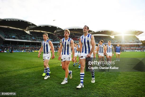 Jack Ziebell, Daniel Nielson and Todd Goldstein of the Kangaroos walk from the ground looking dejected after being defeated by the Power during the...