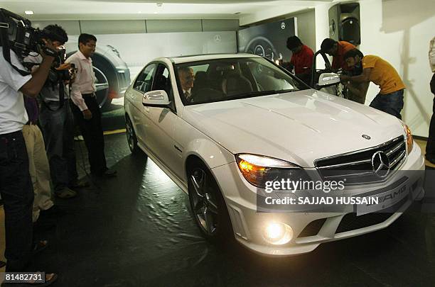 Indian photographers work during the launch of the Mercedes-Benz C 63 AMG sports car in Mumbai on June 7, 2008. The dangerously practical C 63 AMG...