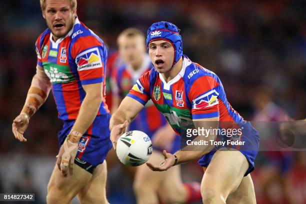 Jamie Buhrer of the Knights offloads the ball during the round 19 NRL match between the Newcastle Knights and the Brisbane Broncos at McDonald Jones...