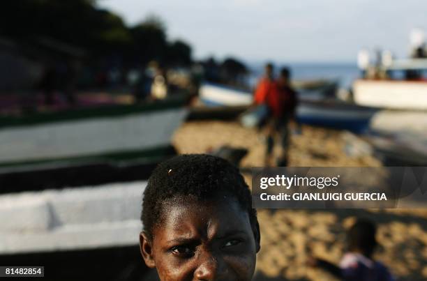 Malawian girl looks up on May 14, 2008 between fishing boats on the shore of Lake Malawi at Senga Bay in Salima district, central Malawi. Home to...