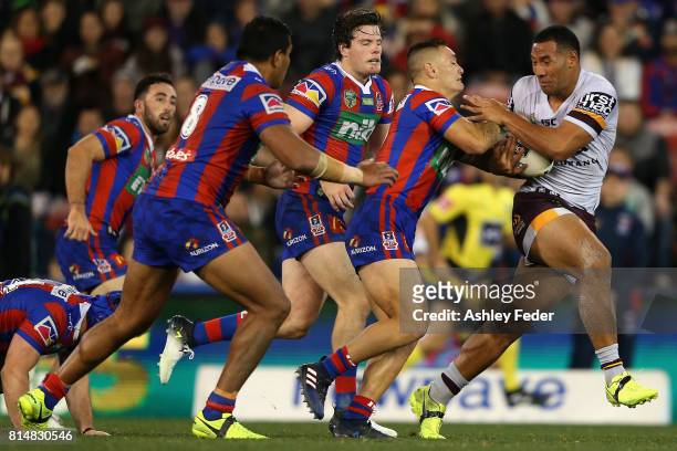 Tautau Moga of the Broncos is tackled by the Knights defence during the round 19 NRL match between the Newcastle Knights and the Brisbane Broncos at...