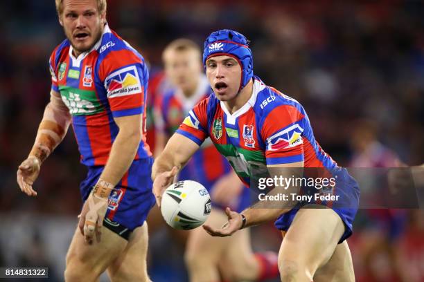 Jamie Buhrer of the Knights offloads the ball during the round 19 NRL match between the Newcastle Knights and the Brisbane Broncos at McDonald Jones...