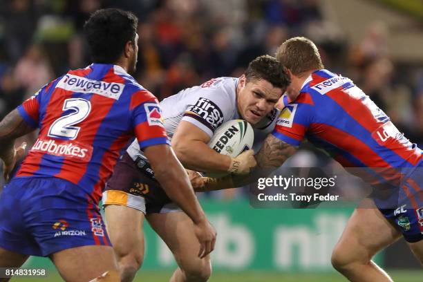 James Roberts of the Broncos is tackled during the round 19 NRL match between the Newcastle Knights and the Brisbane Broncos at McDonald Jones...