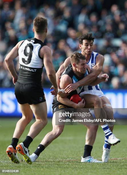 Matt White of the Power is tackled by Robbie Tarrant of the Kangaroos during the 2017 AFL round 17 match between the Port Adelaide Power and the...