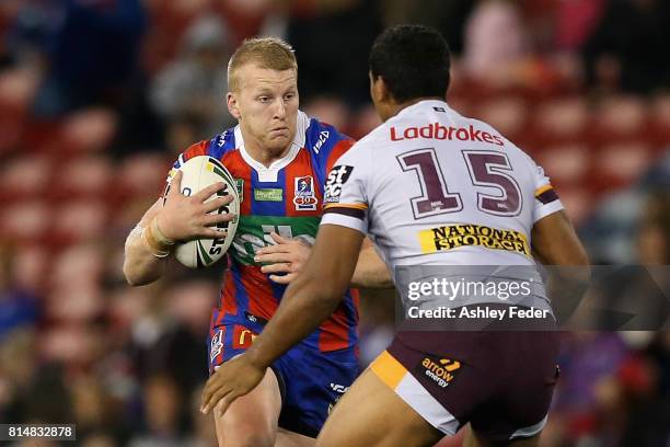 Mitch Barnett of the Knights is tackled by the Broncos defence during the round 19 NRL match between the Newcastle Knights and the Brisbane Broncos...