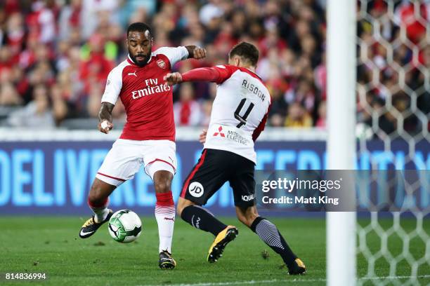 Alexandre Lacazette of Arsenal is challenged by Josh Risdon of the Wanderers during the match between the Western Sydney Wanderers and Arsenal FC at...