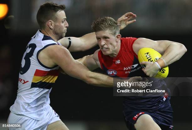 Sam Frost of the Demons is challenged by Brodie Smith of the Crows during the round 17 AFL match between the Melbourne Demons and the Adelaide Crows...